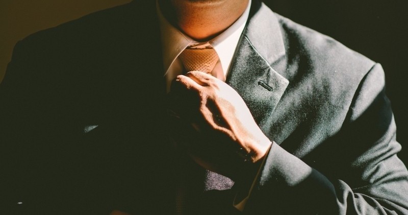 man adjusting tie