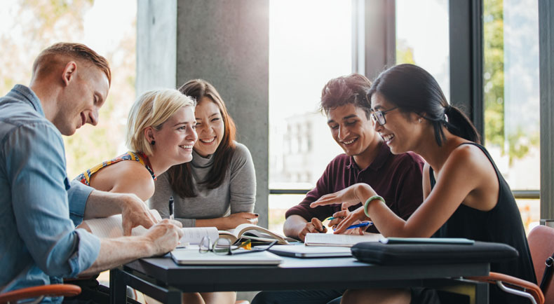 College students gather around a table studying