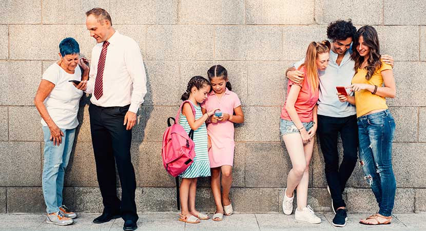 3 groups of people gathered and staring at their cell phones.