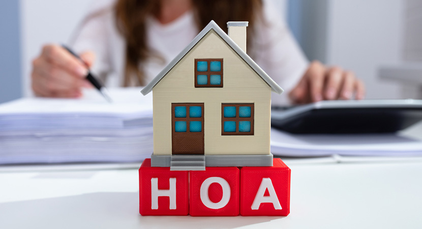 Tiny house on red letters that say HOA