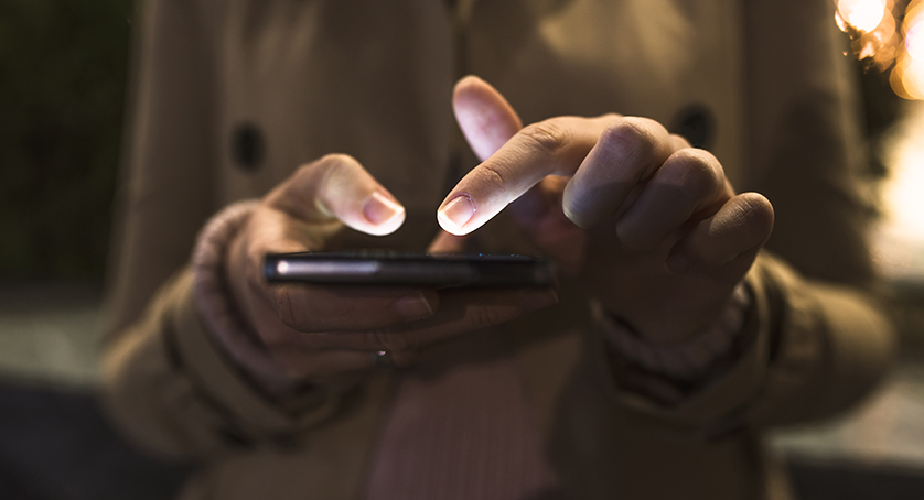 Woman use mobile phone in city at night