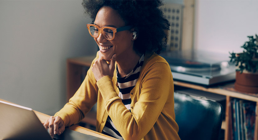 Woman wearing a yellow cardigan looking at available integrations on her computer