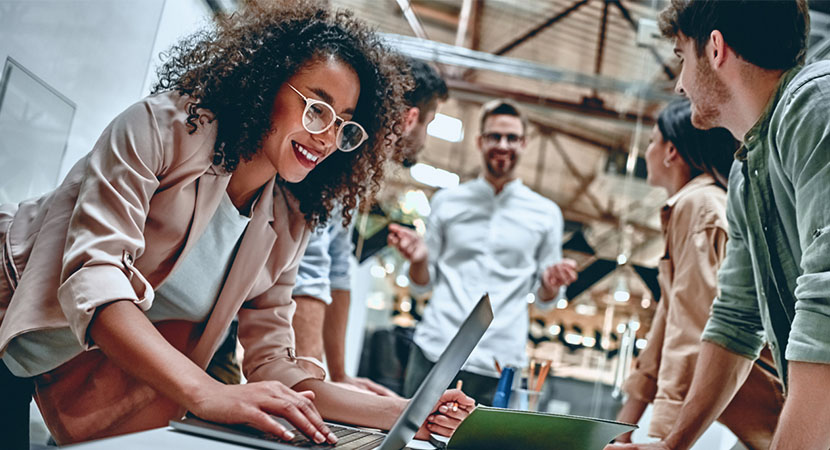 5 people working collaboratively and one is using a computer