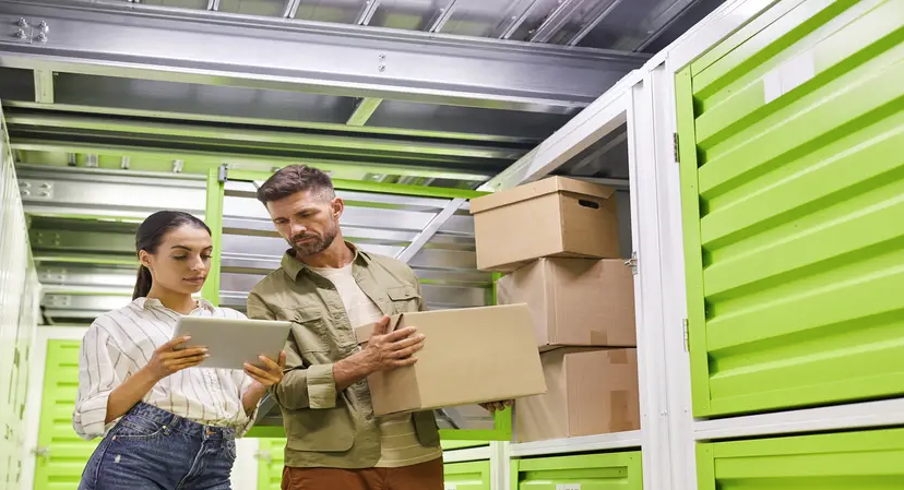 woman checking man into self storage unit using technology