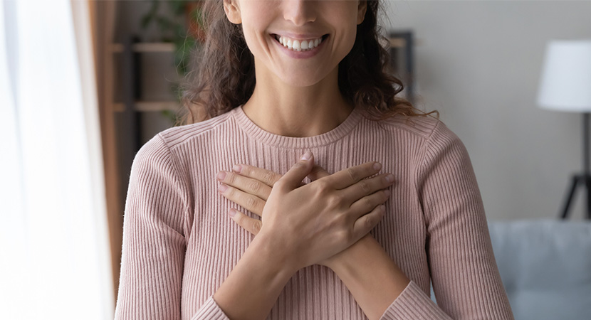 Woman looking thankful and holding her hands to her chest